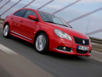 Ein roter Suzuki Kizashi fährt 2010 über eine Brücke.