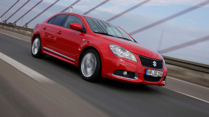 Ein roter Suzuki Kizashi fährt 2010 über eine Brücke.