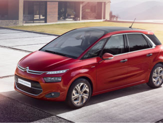 Ein roter Citroën C4 Picasso steht vor einem Haus.