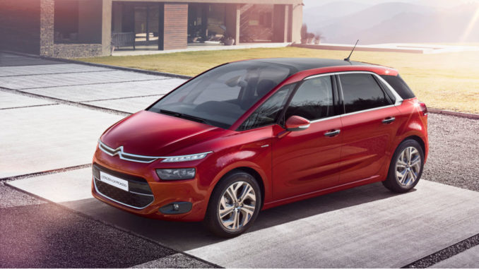 Ein roter Citroën C4 Picasso steht vor einem Haus.