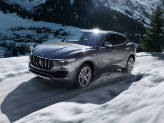 Ein grauer Maserati Levante S fährt auf einem Gebirgspass durch den Schnee.