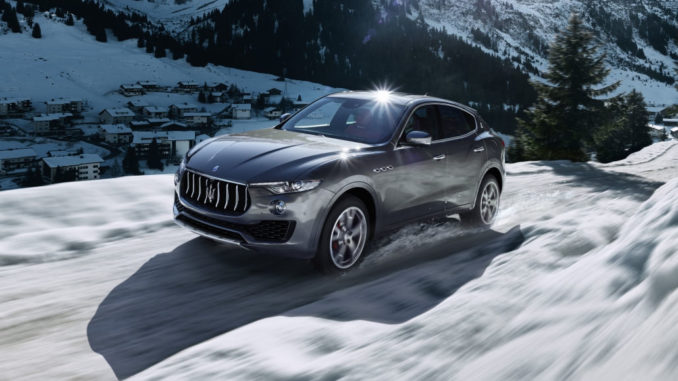 Ein grauer Maserati Levante S fährt auf einem Gebirgspass durch den Schnee.