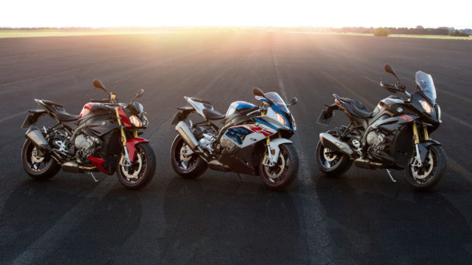 Die drei Motorräder BMW S 1000 R, RR und XR stehen bei Sonnenuntergang auf einer großen Teerfläche.