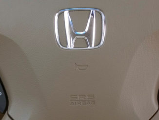 Beiges Lenkrad eine Honda Legend von 2006 mit Logo und Symbol des Airbags und der Hupe.