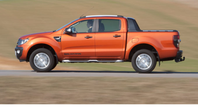 Profil eines Ford Ranger auf einer Landstraße in einer hügeligen Graslandschaft.