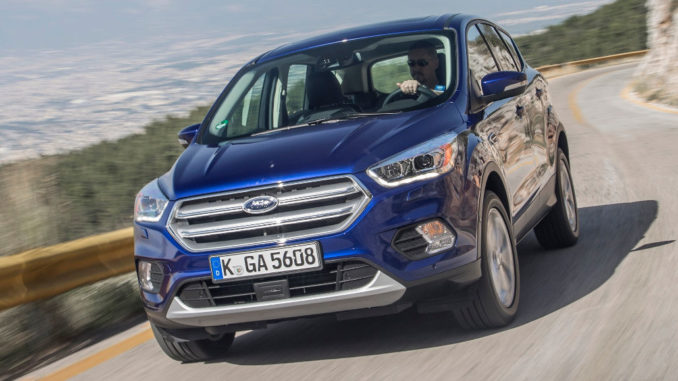 Ein blauer Ford Kuga fährt 2016 auf einer Passstraße.