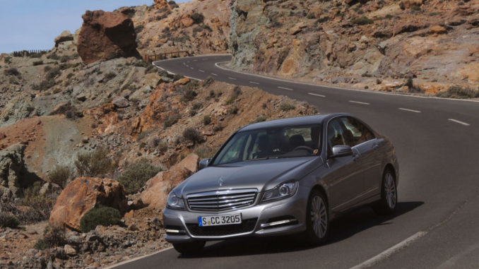 Ein silberner Mercedes-Benz C-Klasse (W204) fährt durch eine Vulkanlandschaft. Mercedes-Benz C-Klasse, C 350 ELEGANCE Limousine (W204; Jahr 2011), palladiumsilber metallic, Leder beige.