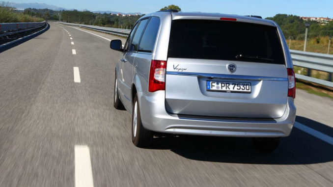 Das Heck eines silbernen Lancia Voyager fährt 2011 auf einer Landstraße.