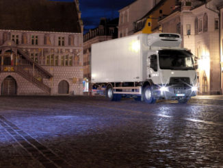 Renault Trucks D Wide mit Assistenzsystemen Spurhaltekontrolle und Notbremsassistent auf dem nächtlichen La Réunion Platz in Mühlhausen (Mulhouse)