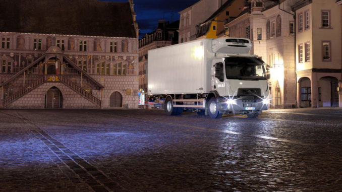Renault Trucks D Wide mit Assistenzsystemen Spurhaltekontrolle und Notbremsassistent auf dem nächtlichen La Réunion Platz in Mühlhausen (Mulhouse)