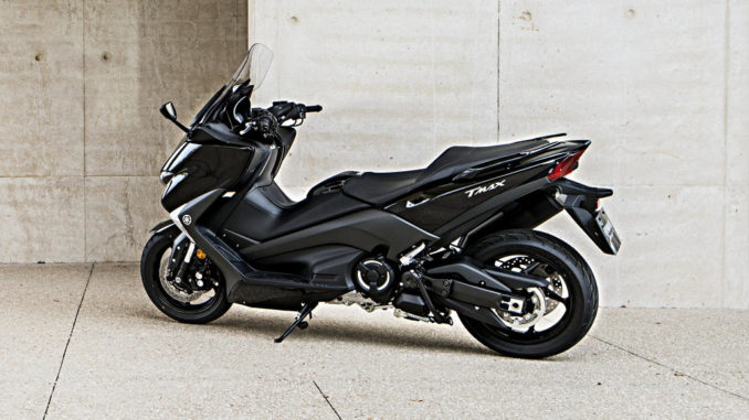 Eine schwarze Yamaha T-Max steht vor einer Betonwand.