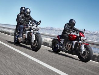 Eine graue Triumph Rocket 3 GT und eine rote Rocket 3 R fahren 2019 auf einer Küstenstraße.