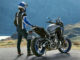 Ein Motorradfahrer steht 2020 mit einer blau-grauen Yamaha Tracer 700 an der Kurve eine Bergpasses.