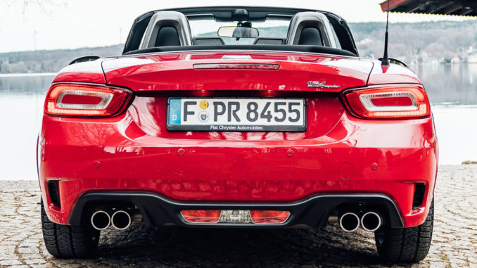 Ein roter Abarth 124 Spider steht 2018 an einem Seeufer.