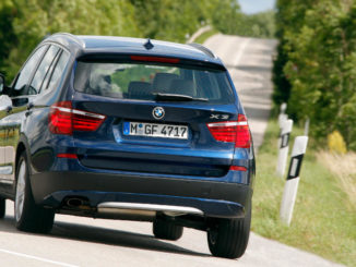 Kurvenfahrt eines blauen BMW X3 (08/2011)