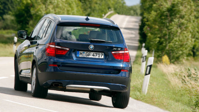 Kurvenfahrt eines blauen BMW X3 (08/2011)