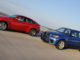 Ein roter BMW X6 M und ein blauer X5 M fahren 2009 auf einer Strandpromenade.
