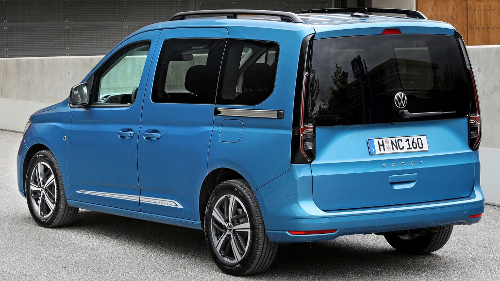 Ein blauer VW Caddy steht 2021 vor einem Holzhaus.