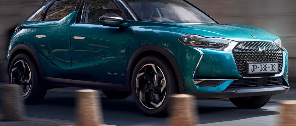 Ein blauer DS3 Crossback fährt durch eine Altstadt.