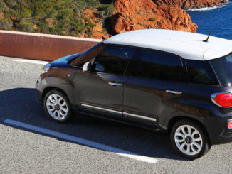 Ein grüner Fiat 500L 1.6 MJT 105 cva auf einer Küstenstraße.