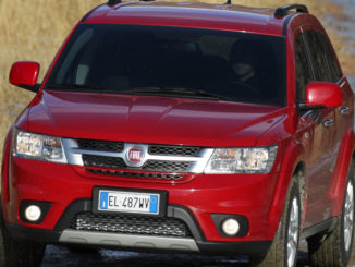 Ein roter Fiat Freemont fährt durch Gelände.