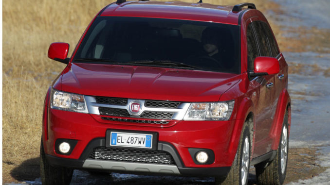 Ein roter Fiat Freemont fährt durch Gelände.