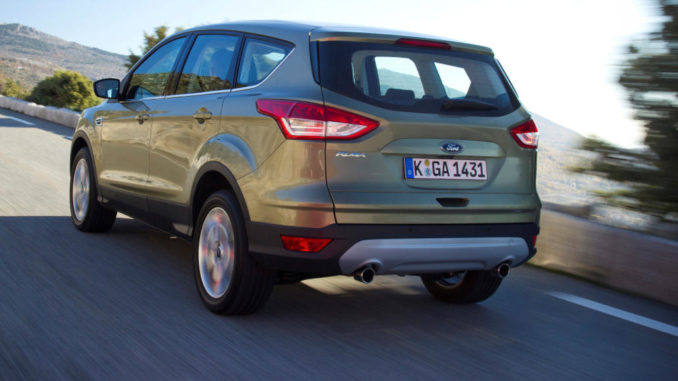 Ein olivgrüner Ford Kuga fährt 2013 auf einer Bergstraße.