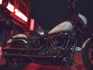 Eine weiße Harley-Davidson Low Rider S steht 2023 nachts vor einer Bar.