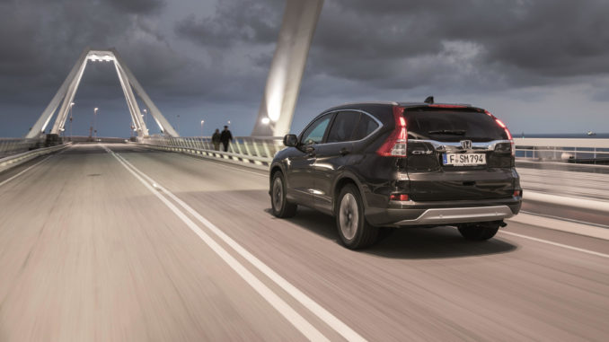 Ein schwarzer Honda CR-V fährt über eine Brücke.