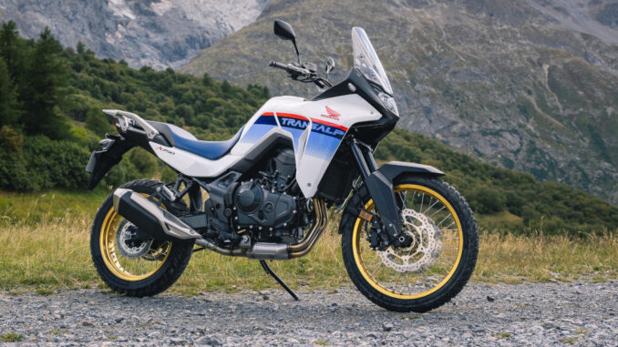 Eine weiße Honda XL 750 Transalp steht 2023 auf einer Schotterpiste in den Alpen.