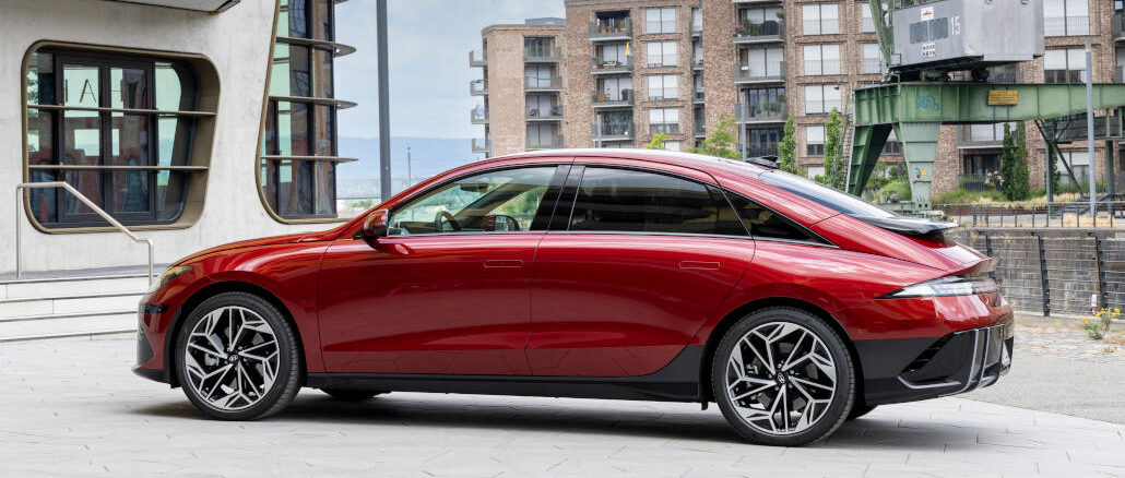 Ein roter Hyundai Ioniq6 steht an einem Binnenhafen.