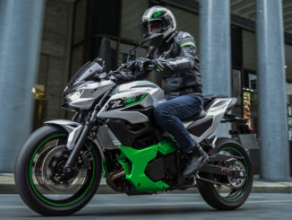 Eine Kawasaki Z7 Hybrid fährt 2024 an einem Bürogebäude vorbei.