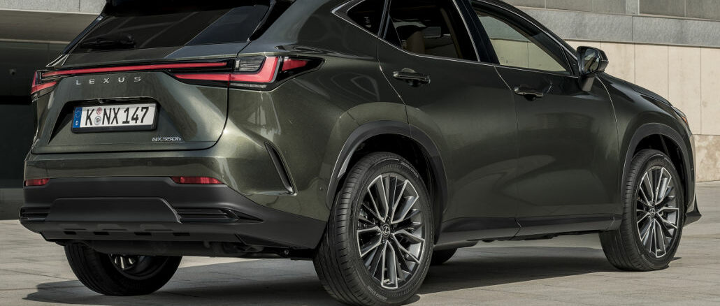 Ein dunkelgrüner Lexus NX 350h steht 2021 vor einer Betonfassade.