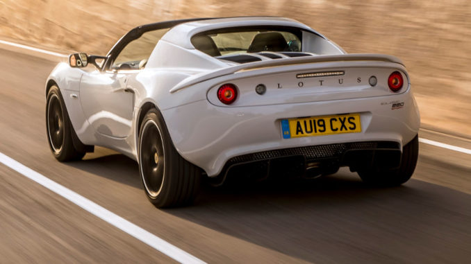 Eine graue Lotus Elise Sport 220 fährt an einer Betonwand vorbei.