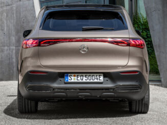 Ein Mercedes-EQ. EQE SUV. AMG Line Exterior, Night Package, Velvet brown metallic, steht 2022 vor einem Gebäude aus Beton.