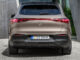 Ein Mercedes-EQ. EQE SUV. AMG Line Exterior, Night Package, Velvet brown metallic, steht 2022 vor einem Gebäude aus Beton.