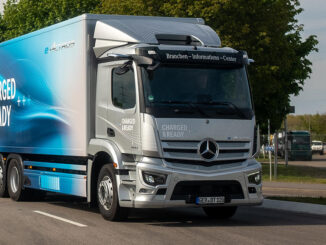 Ein silberner Startschuss Mercedes E-Actros fährt im Rahmen einer Roadshow auf einer Landstraße. Motto: quer durch Europa mit vollelektrischen Lkw