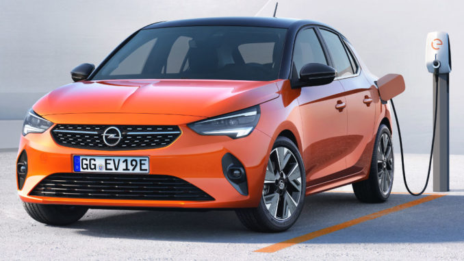 Ein orangener Opel Corsa-e steht 2020 an einer Ladesäule.