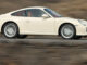 Ein weißer Porsche 911 (997) fährt durch eine Vulkanlandschaft.