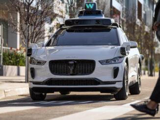 Ein Jaguar I-Pace der Firma Waymo hält an einem Zebrastreifen.