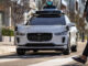 Ein Jaguar I-Pace der Firma Waymo hält an einem Zebrastreifen.