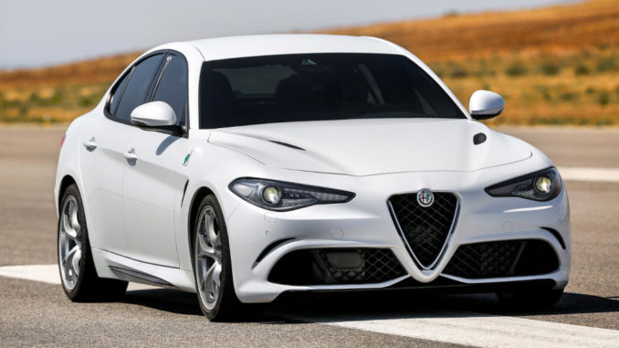 Eine weiße Alfa Romeo Giulia steht 2015 auf einer Straße.