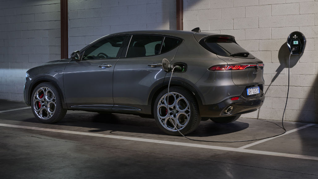 Ein grauer Alfa Romeo Tonale PHEV wird 2023 in einer Garage an einer Wallbox aufgeladen.