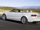Ein weißes Audi A5 Cabrio fährt durch eine Wüstenlandschaft.