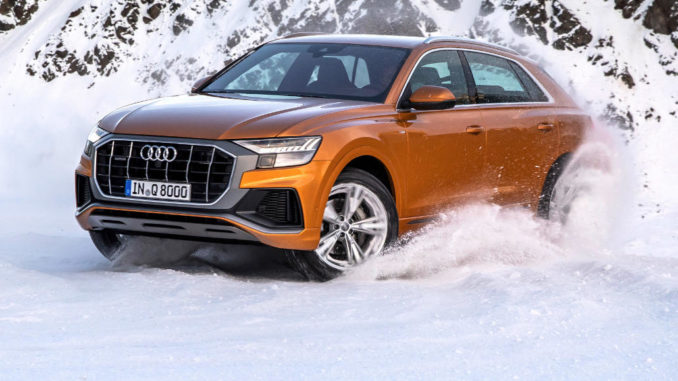 Audi Q8 anno 2018, Fahraufnahme durch den Schnee, Farbe: Drachenorange