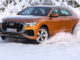 Audi Q8 anno 2018, Fahraufnahme durch den Schnee, Farbe: Drachenorange