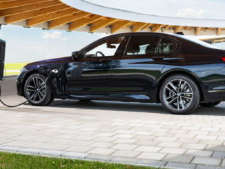 Ein blauer BMW 745e Plugin_hybrid steht 2020 an einer Ladesäule.