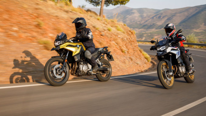 BMW F 750 GS, BMW F 850 GS (11/2017) bei einer Kurvenfahrt auf einer Landstraße in karger Vegetation.