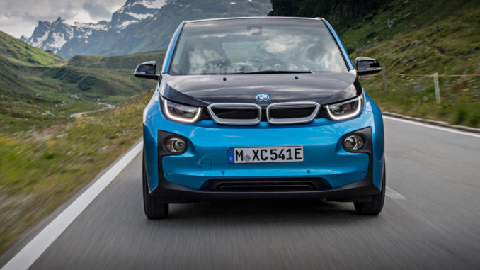 Ein blauer BMW i3 fährt 2016 auf einer Bergstraße.