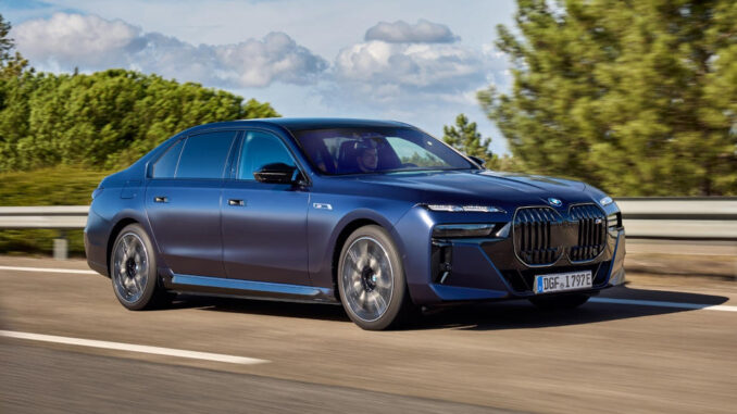 Ein blauer BMW i7 fährt auf einer Autobahn.